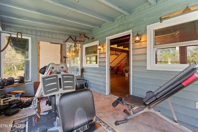 exercise area featuring tile patterned flooring and wooden walls