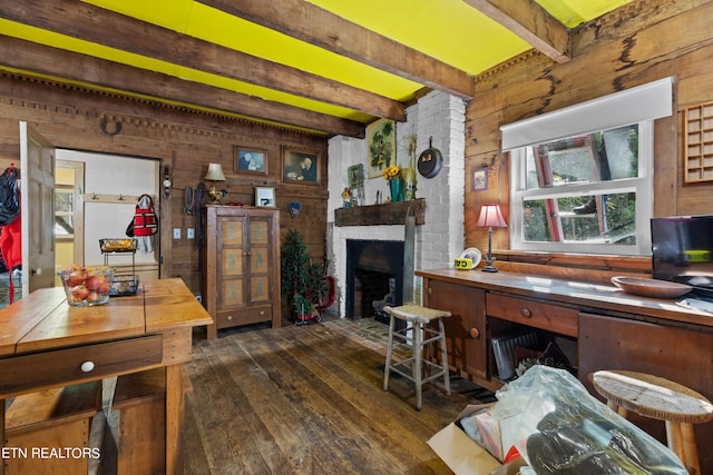 interior space featuring dark wood-style floors, beamed ceiling, wood walls, and a brick fireplace