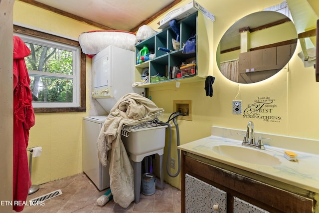 full bath featuring stacked washer and clothes dryer, visible vents, and vanity