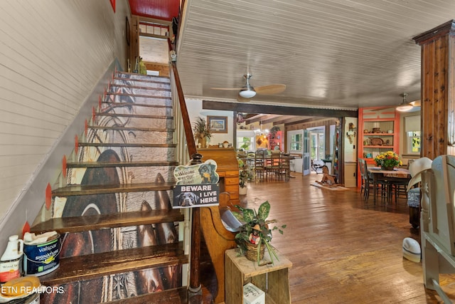 stairway featuring a ceiling fan and wood finished floors