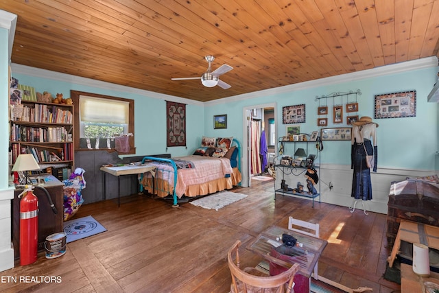 bedroom with wainscoting, wooden ceiling, ornamental molding, and wood-type flooring
