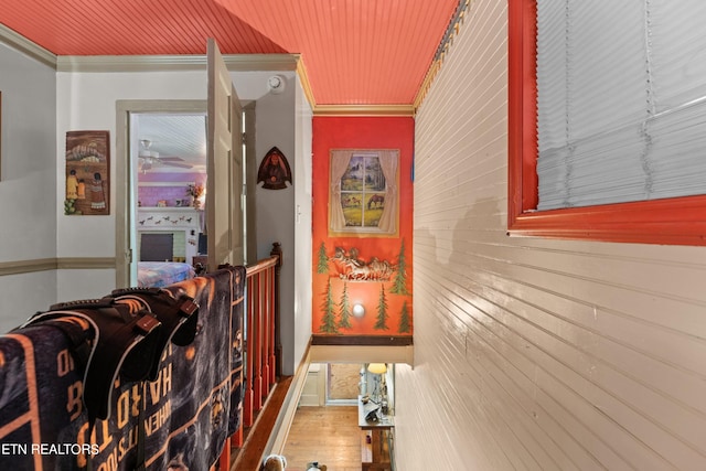 hallway featuring wood finished floors and ornamental molding