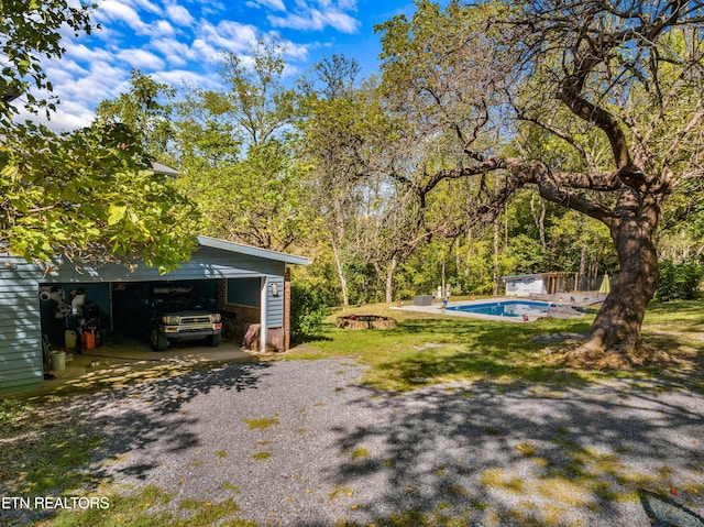 view of yard with an outdoor pool and a detached garage