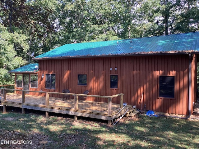 rear view of property featuring a deck and a yard