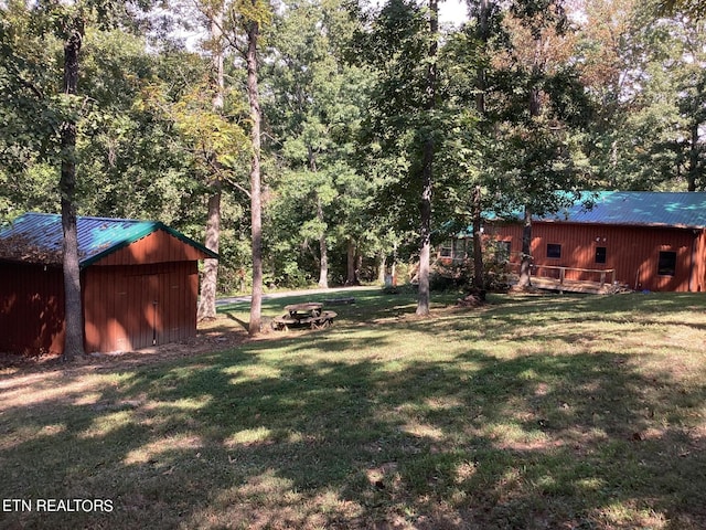 view of yard with an outdoor fire pit, an outbuilding, a storage unit, and a deck