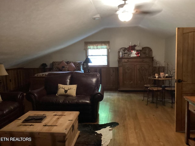 living area featuring lofted ceiling, ceiling fan, and light wood-type flooring