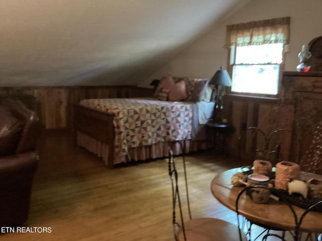 bedroom with vaulted ceiling and light wood-style floors