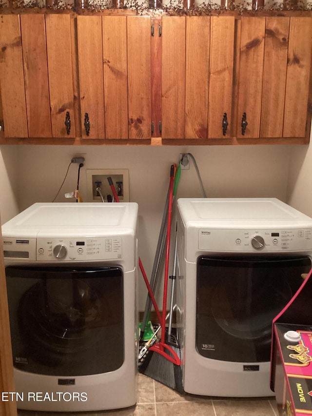 laundry area with cabinet space, independent washer and dryer, and light tile patterned floors