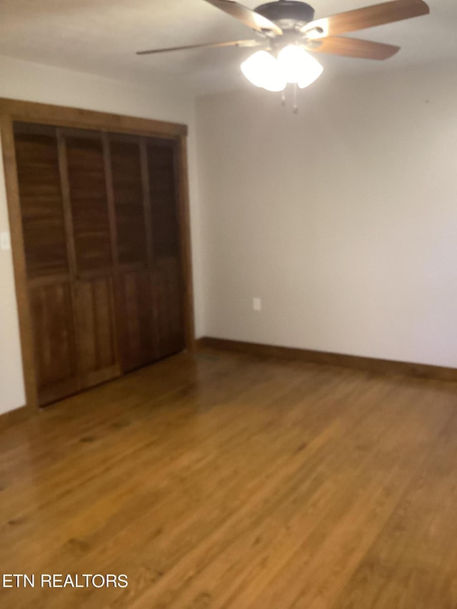 unfurnished bedroom with a closet, wood-type flooring, and ceiling fan