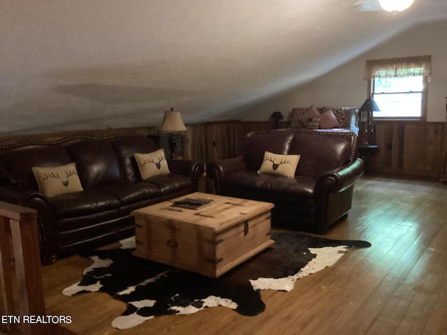 living room featuring wooden walls, vaulted ceiling, and dark hardwood / wood-style flooring