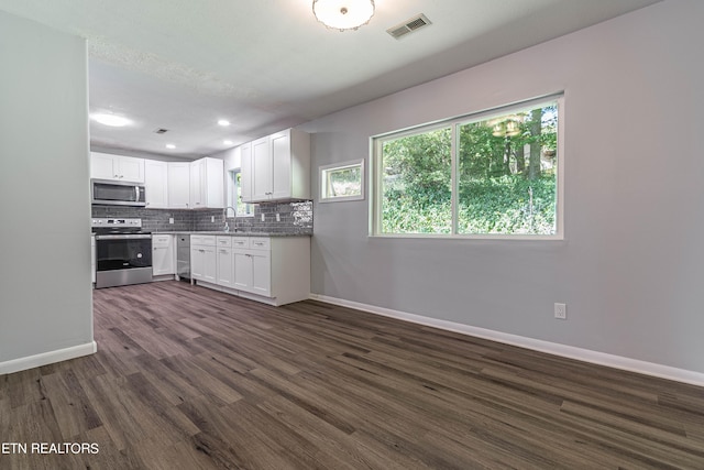 kitchen with sink, dark wood-type flooring, white cabinetry, appliances with stainless steel finishes, and decorative backsplash