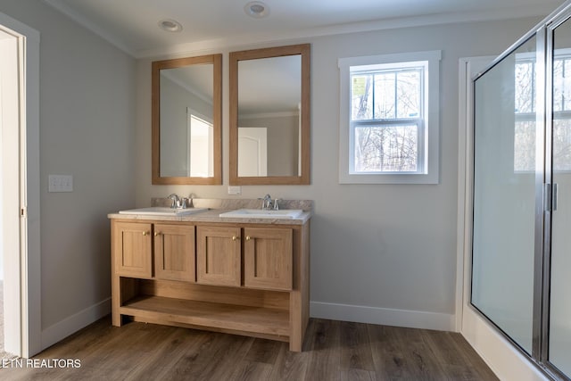 bathroom featuring an enclosed shower, vanity, and ornamental molding