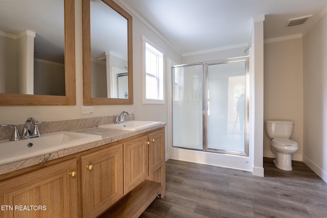 bathroom featuring hardwood / wood-style flooring, toilet, walk in shower, and crown molding