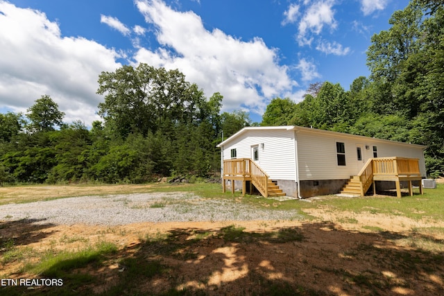 105 Highland Ave, Clinton, TN 37716 - view of yard with stairs, a deck, central air condition unit, and a forest view