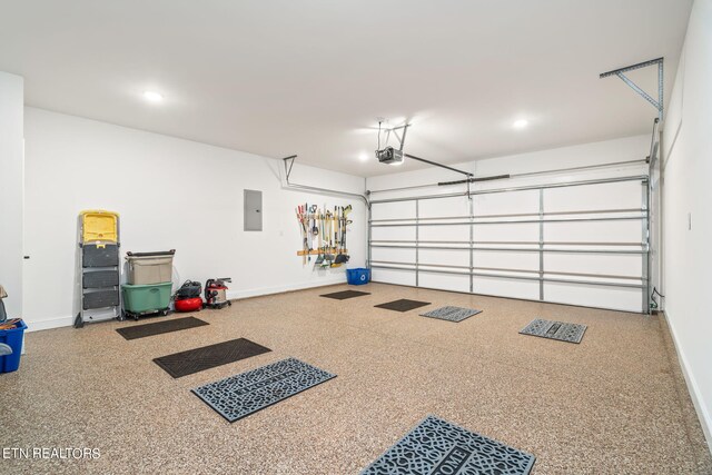 garage with a garage door opener and electric panel