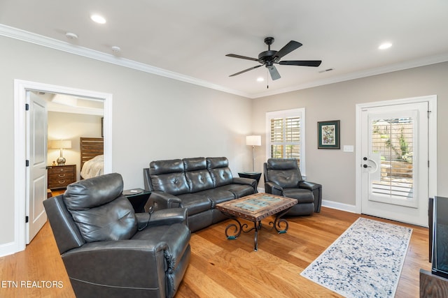 living room with ceiling fan, crown molding, light hardwood / wood-style floors, and a wealth of natural light