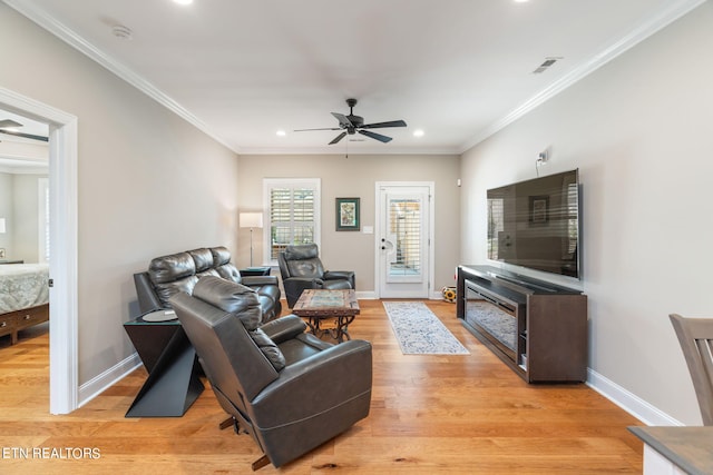 living room featuring light wood-type flooring, ornamental molding, and ceiling fan