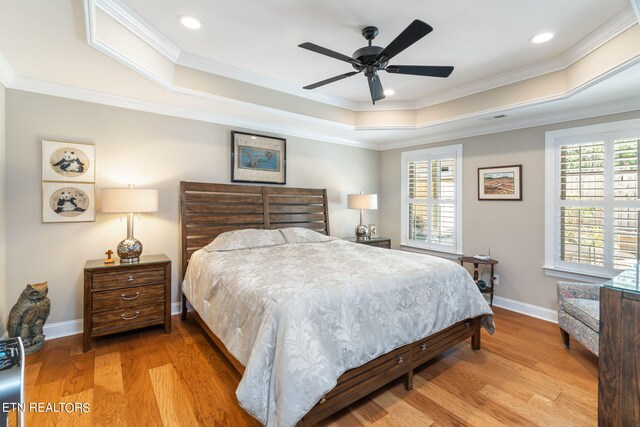 bedroom featuring ornamental molding, a tray ceiling, ceiling fan, and hardwood / wood-style flooring