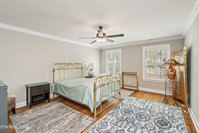 bedroom featuring wood-type flooring, ceiling fan, and crown molding