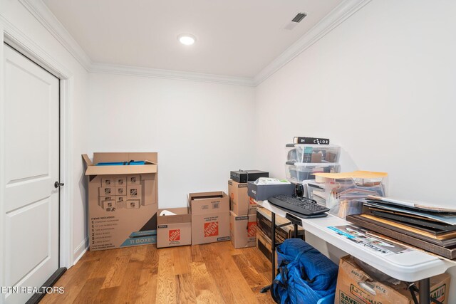 home office featuring light hardwood / wood-style flooring and crown molding