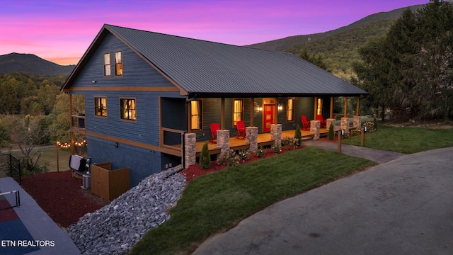 view of front of property with a yard, a mountain view, and covered porch