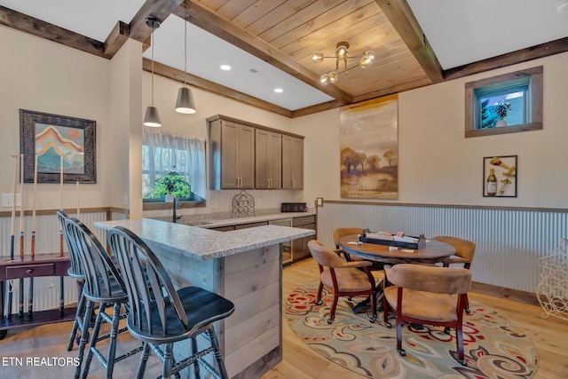 kitchen featuring light stone counters, wood ceiling, sink, light hardwood / wood-style floors, and hanging light fixtures