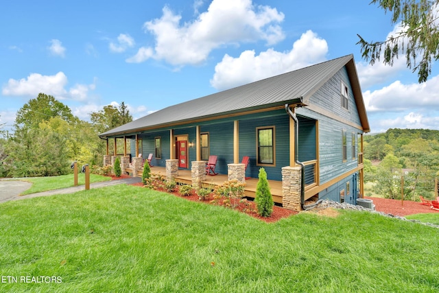 view of front of home with a front yard, covered porch, and central AC unit