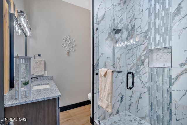 bathroom with walk in shower, vanity, toilet, and hardwood / wood-style flooring