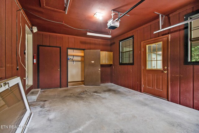 garage with wood walls and a garage door opener