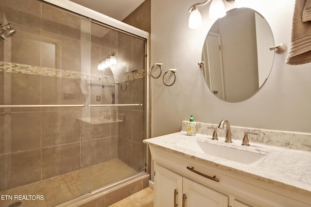 bathroom featuring tile patterned flooring, vanity, and a shower with shower door