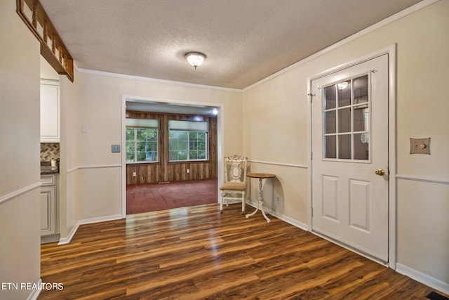 interior space featuring a textured ceiling, dark hardwood / wood-style floors, and ornamental molding