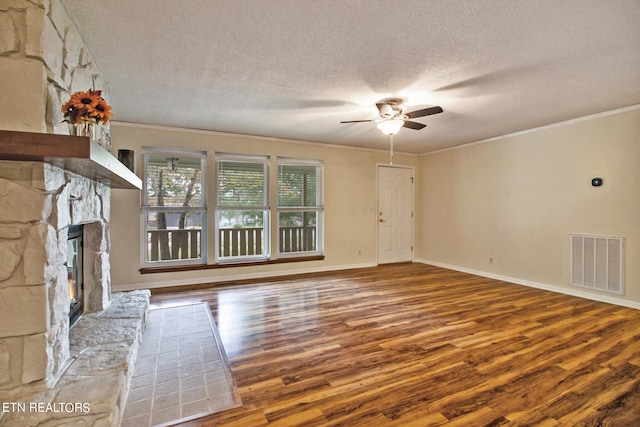 unfurnished living room featuring a fireplace, wood-type flooring, ceiling fan, and a textured ceiling