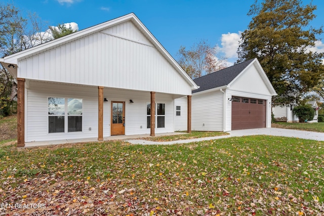 view of front of house featuring a front yard, a garage, and a porch