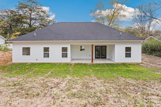 back of property with a patio area and a yard