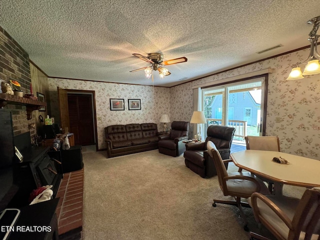 living room with a textured ceiling, a fireplace, carpet, ornamental molding, and ceiling fan