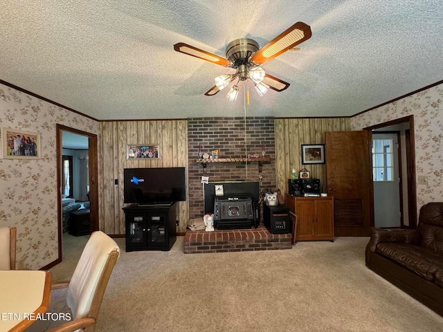 living room with a textured ceiling, ceiling fan, and a wood stove