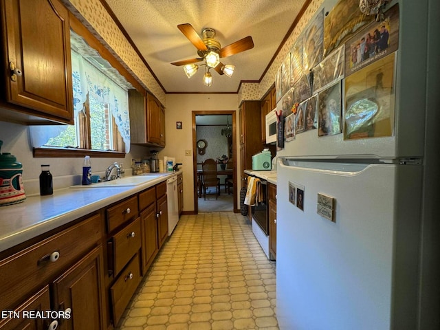 kitchen featuring white appliances, a textured ceiling, crown molding, ceiling fan, and sink