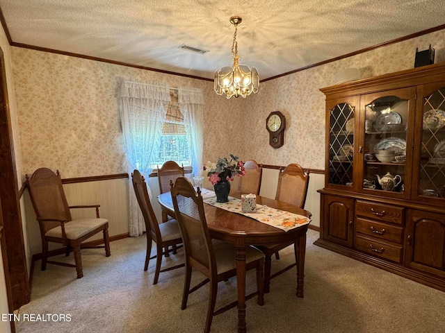 carpeted dining area featuring a textured ceiling, crown molding, and an inviting chandelier