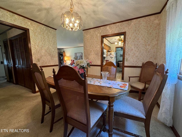 dining area featuring a textured ceiling, ceiling fan with notable chandelier, ornamental molding, and carpet