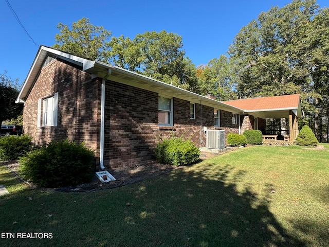 view of side of home featuring a lawn and cooling unit