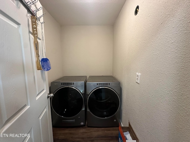 clothes washing area with washer and clothes dryer, a textured ceiling, and dark hardwood / wood-style floors