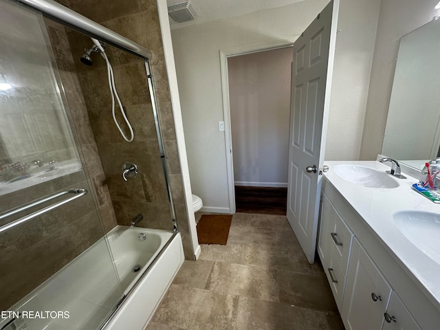 full bathroom with vanity, toilet, and bath / shower combo with glass door