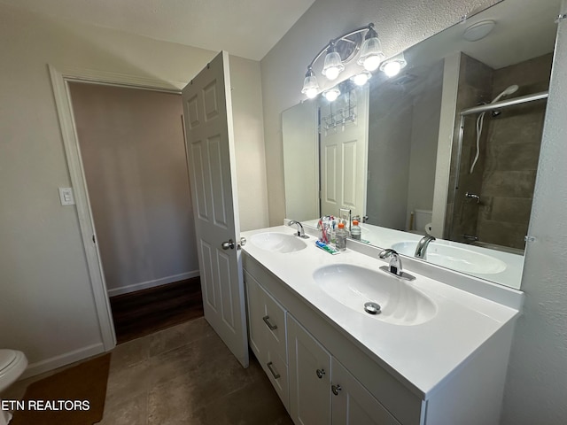 bathroom with wood-type flooring, walk in shower, vanity, and toilet