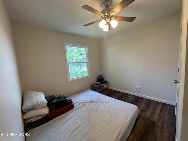 bedroom with dark hardwood / wood-style flooring and ceiling fan