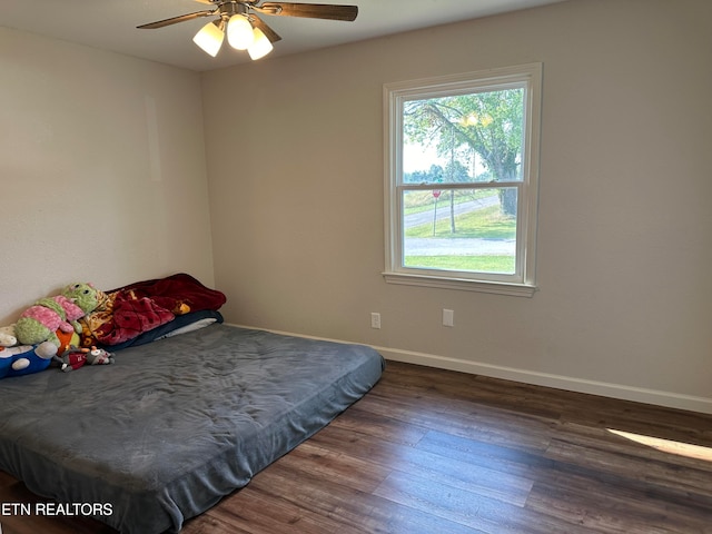 bedroom with ceiling fan and dark wood-type flooring