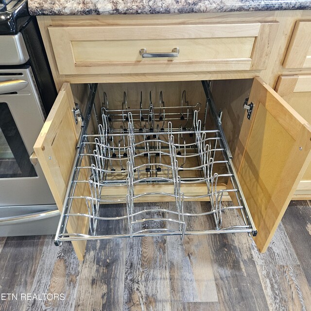 interior details featuring light brown cabinetry, stone counters, and dark wood-type flooring