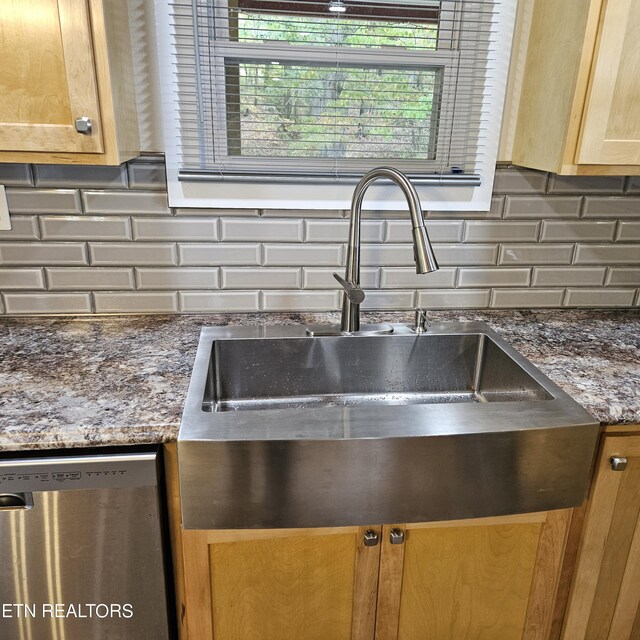 details featuring dark stone countertops, backsplash, sink, and stainless steel dishwasher