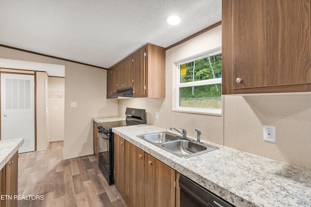 kitchen featuring a textured ceiling, sink, light hardwood / wood-style flooring, black range oven, and crown molding