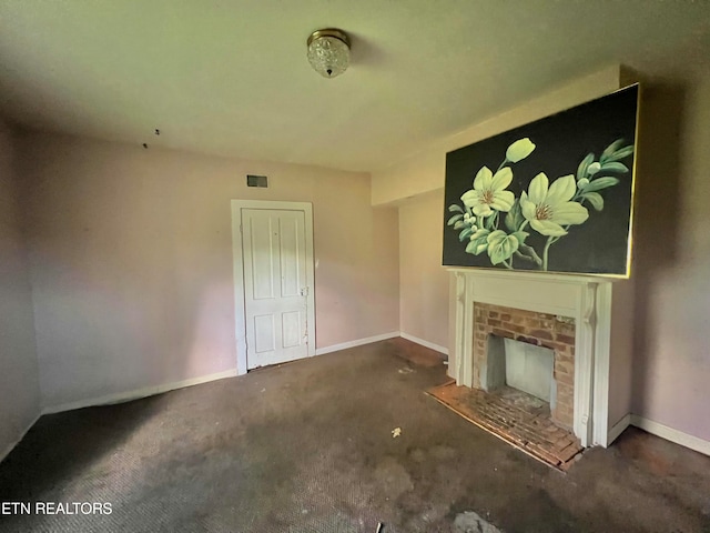 unfurnished living room featuring a fireplace and dark colored carpet