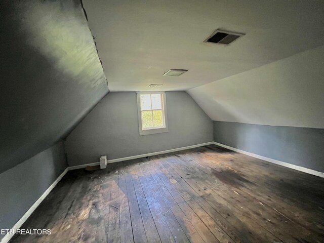 bonus room with vaulted ceiling and dark wood-type flooring